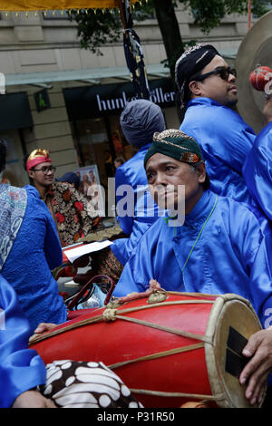 Francfort, Allemagne. 16 Juin, 2018. Un homme de l'Indonésie participe à la parade portant une robe traditionnelle et une coiffure traditionnelle de l'Indonésie, un grand tambour battant. Des milliers de personnes ont participé et assisté à la Parade 2018 der Kulturen (défilé des cultures), organisé par le Frankfurter Jungendring (Conseil de la jeunesse de Francfort). Le défilé avec des participants de plus de 40 différents groupes d'assurance et les organismes culturels à l'honneur la diversité culturelle de Francfort. Crédit : Michael Debets/Pacific Press/Alamy Live News Banque D'Images