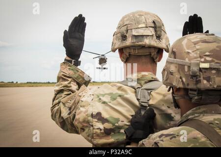 Un soldat avec 2e Brigade Combat Team, 82e Division aéroportée, guides un UH-60 Black Hawk affecté à la 82e Brigade d'aviation de combat, avec les signaux de la main et du bras lors d'un événement de formation à la charge de l'élingue Holland sur la Zone de Fort Bragg, en Caroline du Nord, le 24 août, 2016. (U.S. Photo de l'armée par le capitaine Adan Cazarez) Banque D'Images