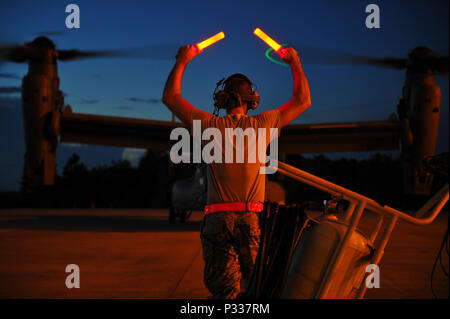 Harrison Bishton Senior Airman, un chef d'équipe avec la 801st Escadron de maintenance des aéronefs d'opérations spéciales, des guides un CV-22B avion à rotors basculants Osprey à Hurlburt Field, en Floride, le 18 août 2016. Les chefs d'équipage avec la 801st SOAMXS S'assurer que les avions sont prêts à voler à tout moment de fournir des forces prêtes au combat à tout moment et en tout lieu. (Photo par un membre de la 1re classe Joseph Pick) Banque D'Images