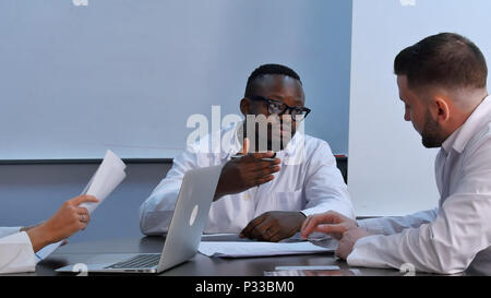 Groupe multiracial de médecins ayant la discussion in office Banque D'Images