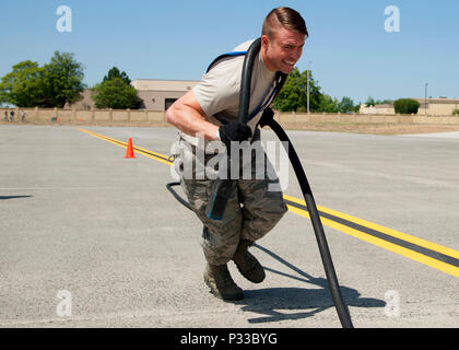Le personnel. Le Sgt. Robert Goodman, 92e Groupe d'entretien général chef d'équipage de vol des aéronefs, les souches pour tirer une 100 pi. de long câble d'alimentation d'aéronefs de l'autre côté de la ligne de vol au cours de la troisième étape de la Fairchild MXG Relais Olympique sur la concurrence, le 5 août 2016, à Fairchild Air Force Base, dans l'état de chaque membre de l'aviateur quatre équipes avaient à sprint à travers la ligne de vol à effectuer leur part du relais avant d'un coéquipier de marquage. (U.S. Air Force photo/Navigant de première classe Ryan Lackey/libérés) Banque D'Images