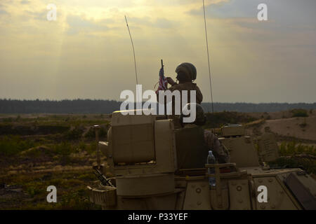 Un soldat du 3e Bataillon interarmes, 69e régiment de blindés, 3ème Division d'Infanterie stationné à Fort Stewart, la Géorgie prépare le drapeau américain sur son M2A2 Bradley pour un exercice de tir réel qui a eu lieu le 30 août 2016 à Pabrade, la Lituanie. Cet exercice a été le cadre de l'opération Atlantic résoudre, un effort dirigé par les États-Unis d'être menées en Europe de l'est pour démontrer l'engagement des États-Unis à la sécurité collective de l'OTAN et son dévouement à la paix durable et la stabilité dans la région. (U.S. Photo de l'armée par la CPS Jordanie Yates/ 3-69 Armor Regiment) Banque D'Images