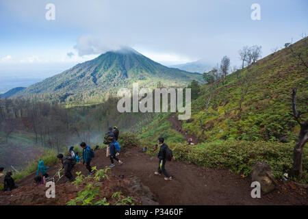 Les visiteurs marchent vers le bas du bord du cratère du volcan Ijen à Java, Indonésie Banque D'Images