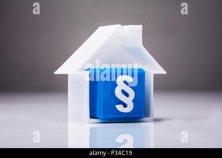 Bloc cube bleu avec symbole paragraphe Dans maison modèle sur Reflective 24 Banque D'Images