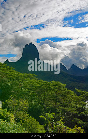 Sommet de montagne dans les collines couvertes de jungle de Moorea avec un fond de nuages spectaculaires contre un ciel bleu. Banque D'Images