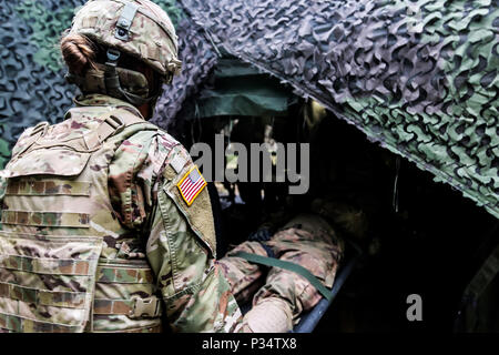 Le s.. Anna Willams, Lubbock, Texas, natif avec le sergent de section 1er Escadron, 2e régiment de cavalerie, déplace un autre soldat d'une tente pour la formation médicale pour Puma 2 exercice avec le groupe de combat en Pologne Bemowo Piskie Domaine de formation, la Pologne le 13 juin 2018 dans le cadre de la grève 18 Sabre. L'exercice de cette année, qui se déroulera du 3 au 15 juin, des tests des alliés et des partenaires de 19 pays sur la capacité de travailler ensemble pour prévenir les agressions dans la région et d'améliorer la capacité de chaque unité d'effectuer leur mission. (U.S. Photo de l'armée par la CPS. Hubert D. Delany III /22e Détachement des affaires publiques Mobiles Banque D'Images