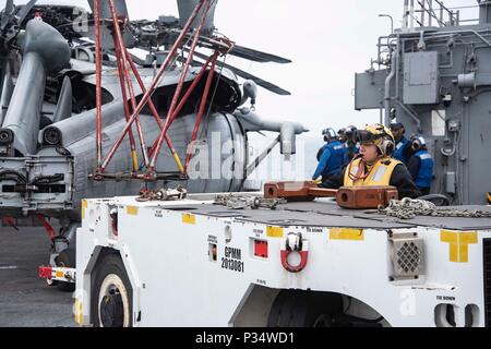 180612-N-RP442-020 OCÉAN PACIFIQUE (12 juin 2018) l'Aviation- maître de Manœuvre (manutention) Amy Fogelbach conduit un P-25 tracteur pour repositionner un hélicoptère MH-60S Seahawk, attaché à la "matraques" d'hélicoptères de l'Escadron de Combat de mer (HSC), 21 dans le poste de pilotage de la classe Wasp-navire d'assaut amphibie USS Essex (DG 2) au cours de l'exercice de l'unité de formation composite (COMPTUEX). COMPTUEX est le dernier exercice de pré-déploiement qui certifie l'Essex combiné Groupe amphibie et 13e Marine Expeditionary Unit ses capacités à mener des opérations militaires en mer et à terre pendant leur puissance projet upco Banque D'Images
