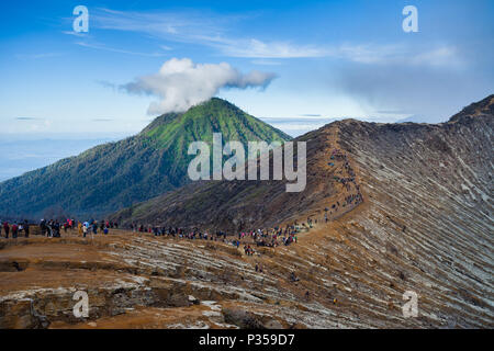 Les visiteurs marchent le long du bord de la cratère du volcan Ijen à Java, Indonésie Banque D'Images