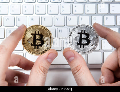 Clavier et de deux pièces en bitcoin la main d'un homme close up Banque D'Images