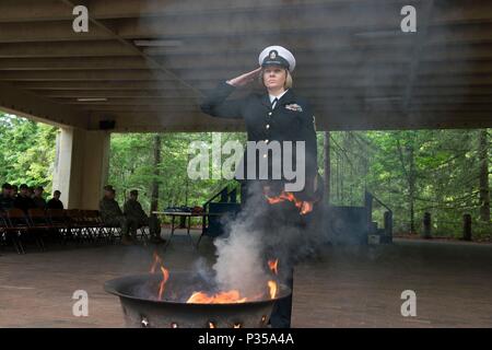 BANGOR, Washington (14 juin 2018) Chef de l'Hospital Corpsman Farrah Ocasio, de Detroit, Michigan, attribué à Trident Centre de formation à Bangor, Washington, rend un hommage après avoir placé les restes d'un drapeau américain dans un feu au cours d'une cérémonie à la retraite drapeau Naval Base Kitsap-Bangor. Lorsqu'un drapeau des États-Unis est usé, déchiré, délavées ou très sale, il devrait être à la retraite dans la dignité et le respect qui sied à elle. BANGOR, Washington (14 juin 2018) 1ère classe musicien Chris Hodges, de Tuscaloosa, en Alabama, attribué à bande marine nord-ouest, joue de la trompette au cours d'une cérémonie à la retraite drapeau Naval Base Kitsa Banque D'Images