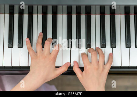 Les mains des enfants jouent du piano. La main de l'enfant sur les touches de piano Banque D'Images