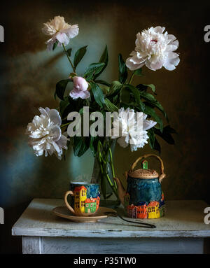 Nature morte avec fleurs et une tasse de thé. Un bouquet de pivoines. la céramique faite à la main. Banque D'Images