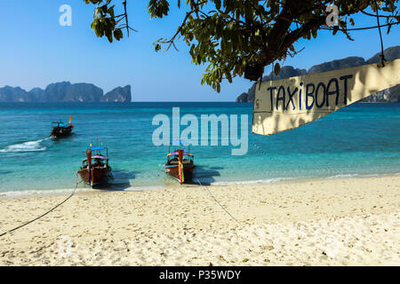 Bateaux à longue queue près de la plage de Ko Phi Phi Don, et un panneau en bois bateau taxi suspendu à l'arbre. Les îles Phi Phi, Thaïlande Banque D'Images