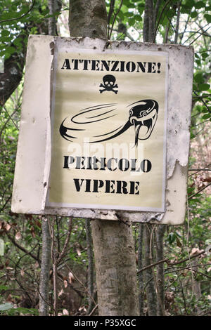 La toscane, italie. Un signe sur un sentier à travers les marcheurs avertissement forestiers pour regarder dehors pour des serpents venimeux (additionneurs) Banque D'Images