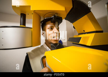 Vue de la récolte de l'homme noir faire une radiographie des dents sur la machine colorés. Banque D'Images