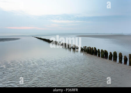 Une ligne de poteaux qui mène à la mer du Nord en Norderney, Allemagne. L'exposition à long shot. Banque D'Images