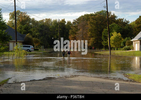 Bossier City, en Louisiane, - le 30 octobre 2009 : les enfants de l'école Wade à travers une rue résidentielle inondées. Banque D'Images