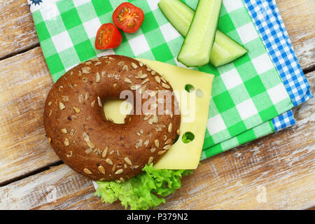 École en santé le déjeuner composé de bagel au fromage à la crème, de concombre et de tomates cerises Banque D'Images