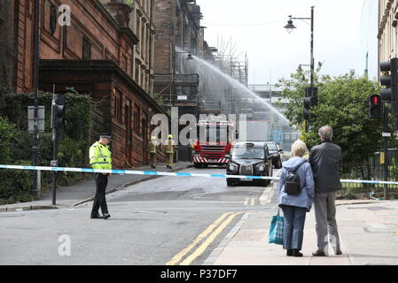 Les membres du public d'oeil sur les pompiers continuent d'atténuer après l'incendie à la Glasgow School of Art (GSA) dans le bâtiment historique de Mackintosh à Glasgow. Banque D'Images