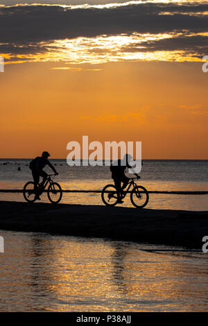 Deux hommes en silhouette ride vtt sur la côte Adriatique, près de la ville de Piran en Slovénie. Banque D'Images