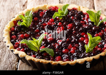 Tarte maison avec baies d'été à la menthe et libre dans un plat allant au four, sur une table horizontale. Banque D'Images