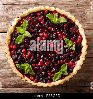 Dessert : tarte d'été avec des baies de cassis, de bleuets et de canneberges close-up dans un plat allant au four, sur une table. haut Vue de dessus Banque D'Images