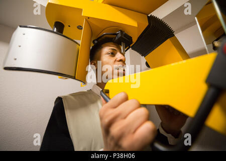 Vue de la récolte de l'homme noir faire une radiographie des dents sur la machine colorés. Banque D'Images