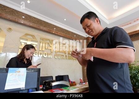 (180618) -- NANCHANG, 18 juin 2018 (Xinhua) -- Zou Yujiang (R) et des biens propriétaire effacer les frais de transport à un marché des matériaux de construction dans le comté de Changting, sud-est, la province de Fujian en Chine, le 13 juin 2018. Zou Yujiang, 41 ans, est un chauffeur de camion de Gao'an, Ville de la province de Jiangxi. Il a passé la majeure partie de son temps sur la route, le transport des marchandises d'un endroit à l'autre. Il y a eu plus de 21 millions d'employés dans l'industrie du transport routier de marchandises en Chine jusqu'à présent. Comme Zou Yujiang, la plupart d'entre eux vivent sur les chariots avec peu de temps d'un séjour avec les familles. Leur Banque D'Images