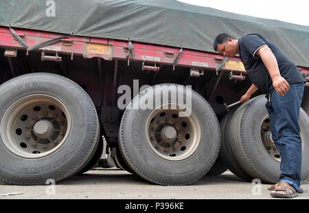 (180618) -- NANCHANG, 18 juin 2018 (Xinhua) -- Zou Yujiang pneus vérifie avant de partir à Gao'an City, province de Jiangxi, Chine orientale, le 12 juin 2018. Zou Yujiang, 41 ans, est un chauffeur de camion de Gao'an, Ville de la province de Jiangxi. Il a passé la majeure partie de son temps sur la route, le transport des marchandises d'un endroit à l'autre. Il y a eu plus de 21 millions d'employés dans l'industrie du transport routier de marchandises en Chine jusqu'à présent. Comme Zou Yujiang, la plupart d'entre eux vivent sur les chariots avec peu de temps d'un séjour avec les familles. Leur travaux ont contribué à la livraison rapide et fiable Banque D'Images