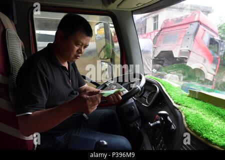 (180618) -- NANCHANG, 18 juin 2018 (Xinhua) -- l'adresse Yujiang Zou confirme avant de démarrer en Gao'an City, province de Jiangxi, Chine orientale, le 12 juin 2018. Zou Yujiang, 41 ans, est un chauffeur de camion de Gao'an, Ville de la province de Jiangxi. Il a passé la majeure partie de son temps sur la route, le transport des marchandises d'un endroit à l'autre. Il y a eu plus de 21 millions d'employés dans l'industrie du transport routier de marchandises en Chine jusqu'à présent. Comme Zou Yujiang, la plupart d'entre eux vivent sur les chariots avec peu de temps d'un séjour avec les familles. Leur travaux ont contribué à la restauration rapide et fiable del Banque D'Images