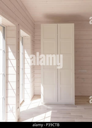 Appartements de style scandinave. La lumière de l'intérieur chambre à coucher dans une maison en bois organiques de couleur blanche. Les meubles Ikea, armoire. Parquet au sol, murs, plafond en bois. Placard blanc. Fenêtres panoramiques Banque D'Images