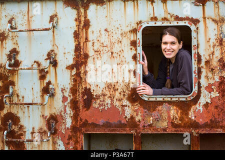 Portrait de femme dans la fenêtre d'un wagon rouillé fer abandonnée. Banque D'Images