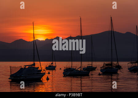 Bateaux à voile sur le lac de Garde avec le coucher du soleil, Italie Banque D'Images