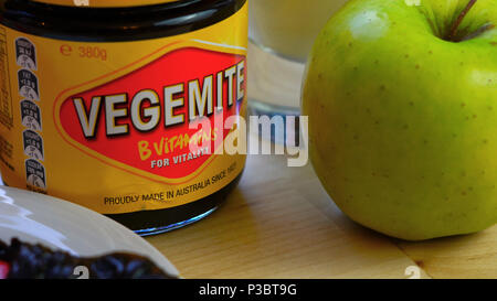 Adelaide, South Adelaide - 6 juin 2018 : Australian Vegemite répartis dans des pot rouge et jaune servi avec un verre de lait et de pomme verte. Banque D'Images