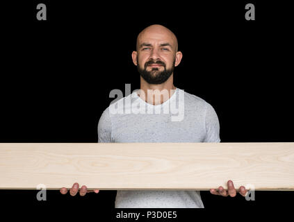 Carpenter barbu chauve est titulaire d'un frêne dans ses mains. copier l'espace. sur un fond noir. Banque D'Images