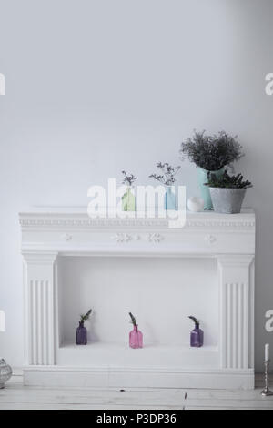 Cheminée avec ornements décoratifs blancs et des photo sur le mur dans la salle de séjour Banque D'Images