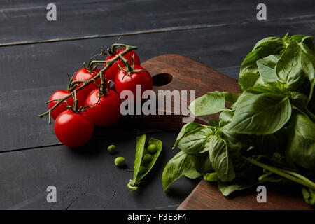 Des légumes frais et des herbes sur un fond de bois sombre. Banque D'Images