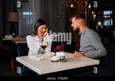 Portrait de jeune femme heureux et surpris de recevoir des présents de petit ami alors qu'il était assis dans le café Banque D'Images