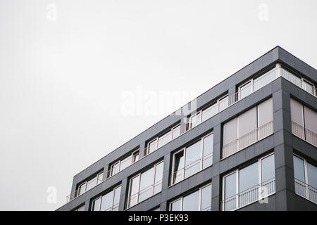 L'angle du bâtiment avec de nombreuses fenêtres contre le ciel gris Banque D'Images