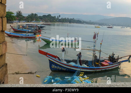 Koh Samui, Thaïlande, Côte Est Baan Hua Thanon. Un village de pêcheurs musulmans. Pêcheur plie ses filets dans son bateau Banque D'Images