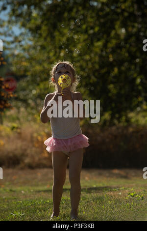 Cute girl Playing with bubble wand Banque D'Images