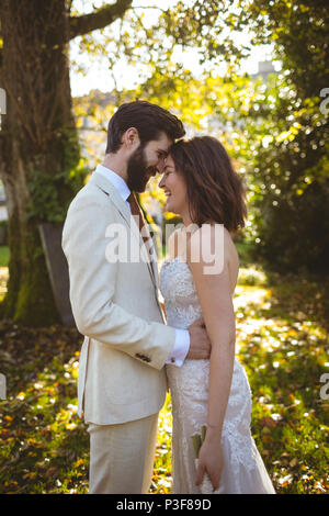 Smiling couple embracing dans le jardin Banque D'Images