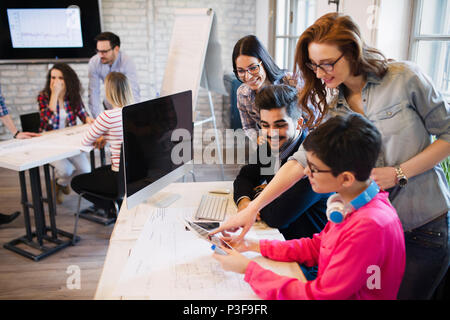 Groupe de jeunes créateurs looking at digital tablet Banque D'Images