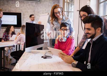 Groupe de jeunes designers en vue de discuter du bureau Banque D'Images