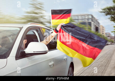 Voiture avec des drapeaux allemands de soufflage Banque D'Images