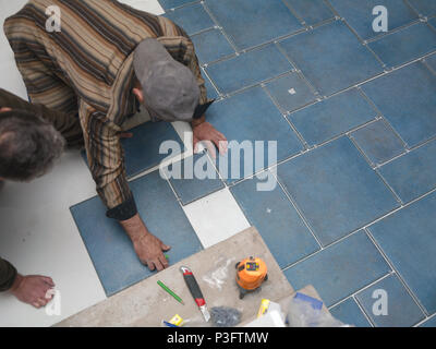 Deux carreleurs travaillent ensemble, notamment les frais généraux d'intérieur tourné Banque D'Images