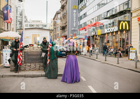 Berlin, 1 octobre 2017 : la femme arabe positive les touristes à côté de la célèbre attraction de la ville appelée Chekpoint Charlie Banque D'Images