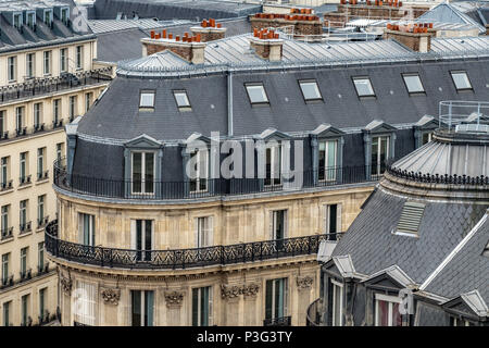 L'élégante ardoise gris toits de Paris les immeubles d'un balcon et de chambres mansardées, Boulevard Haussmann, Paris, France Banque D'Images