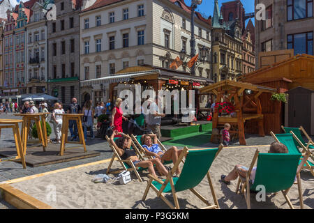 Les habitants et les touristes vous détendre sur des chaises longues au soleil sur la plage de fortune dans la place du marché, Wrocław, Pologne Banque D'Images