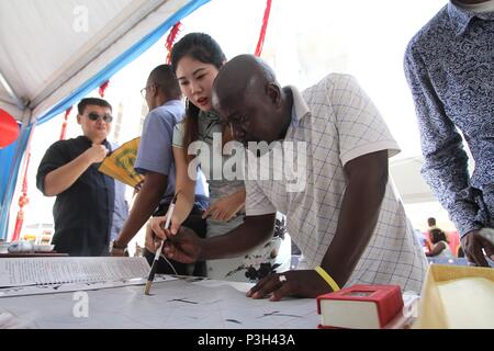 (180618) -- BEIJING, 18 juin 2018 (Xinhua) -- un enseignant de Chinois de l'Institut Confucius de l'Université de Dodoma, un homme apprend à écrire calligraphie chinoise lors d'une exposition à l'occasion du Nouvel An chinois à Dar es Salaam, Tanzanie, le 9 février 2018. (Xinhua) (nxl) Banque D'Images